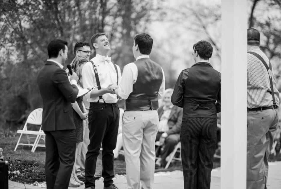 Grooms laughing during ceremony under pergola in Wedding Garden at Gettysburg Battlefield Bed and Breakfast Inn and Wedding Venue, an award-winning South Central Pennsylvania wedding venue in Adams County, PA.